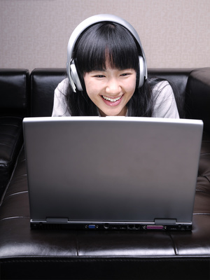 Enjoying Asian Girl with Laptop and Headphones